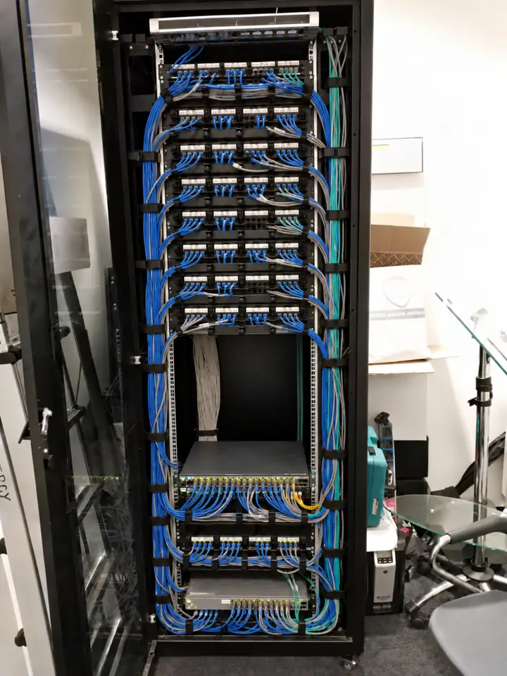 Armadio rack dopo l'intervento: cavi di rete ordinati per colore e fascettati